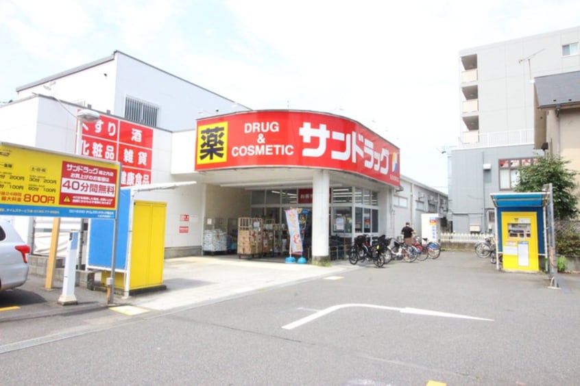 サンドラッグ　京王堀之内駅前店(ドラッグストア)まで899m フレクション多摩ニュータウンⅢ