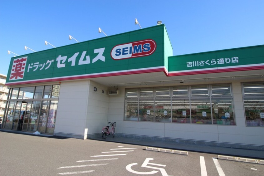 セイムス　吉川さくら通り店(ドラッグストア)まで300m ﾒｲﾝｼﾃｨｶﾞｰﾃﾞﾝ ﾚｼﾞﾃﾞﾝｽ吉川