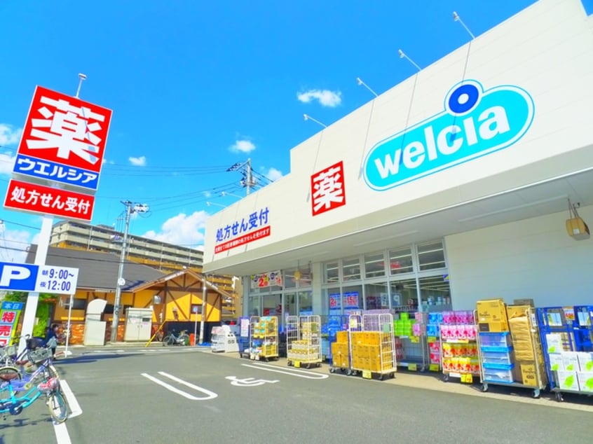 ウエルシア足立竹の塚店(ドラッグストア)まで500m ヴィラ竹ノ塚
